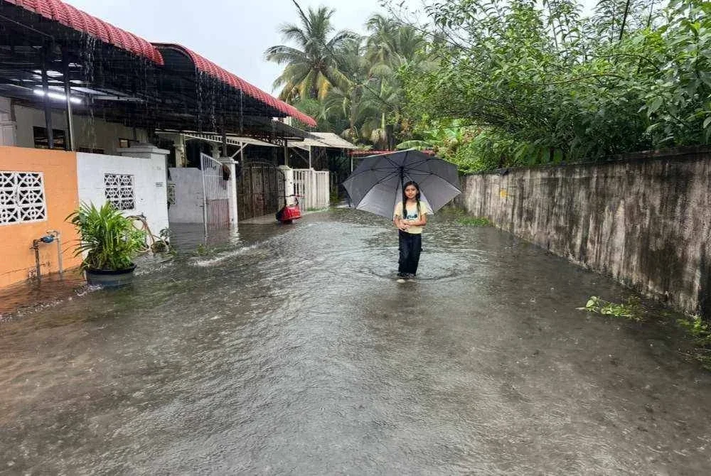 Kanak-kanak mengharungi air yang membanjiri kawasan Taman Perindustrian Golf. - Foto Sinar Harian/ Adila Sharinni Wahid