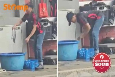 Seorang pekerja membersihkan ikan dekat saluran sampah. - Foto Stomp