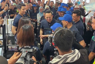 Steven (tengah) sedang mendengar penerangan di reruai yang dilawatinya di Festival Mega iLINDUNGu di Bukit Mertajam pada Sabtu.