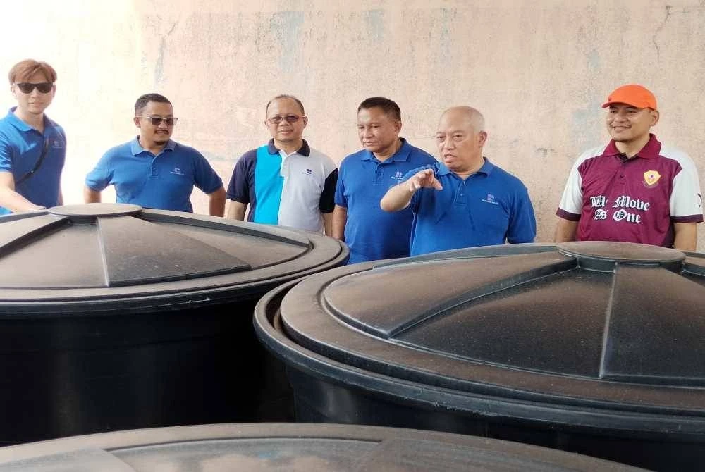 Zulkiflee (dua, kanan) berkata sesuatu ketika meninjau tangki air baharu yang menggantikan tangki air lama di SK Gambut.