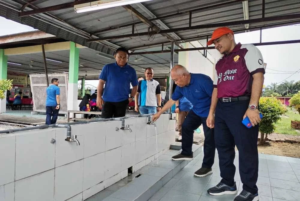 Zulkiflee (dua, kanan) meninjau kawasan mengambil wuduk yang turut dipasang alat peranti cekap air bagi tujuan penjimatan air di SK Gambut.