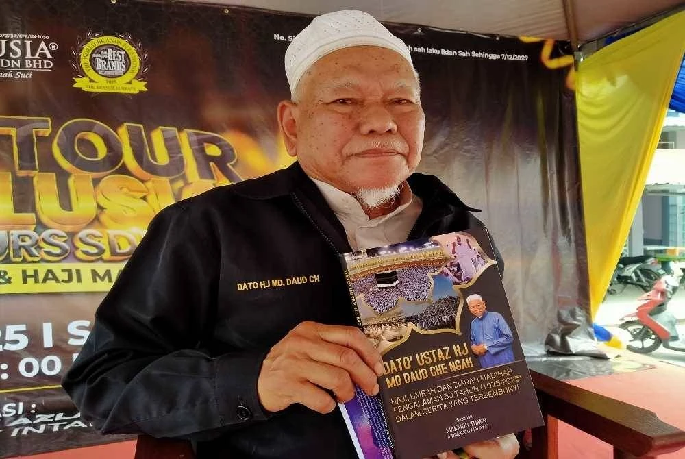 Md Daud menunjukkan buku terbaharu dihasilkan mengenai pengalaman selama 50 tahun sebagai pembimbing haji.