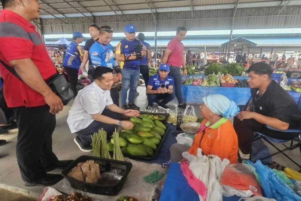 Arthur ketika menyantuni salah seorang peniaga di Tamu Pekan Sook.