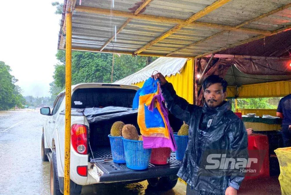 Pekerja gerai durian segera berkemas selepas air naik mendadak. Foto: HAZELEN LIANA KAMARUDIN.