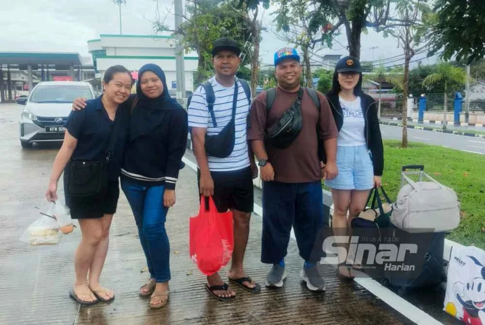 Amir (tengah) bersama rakannya yang tiba di Bukit Kayu Hitam pada pagi Ahad.