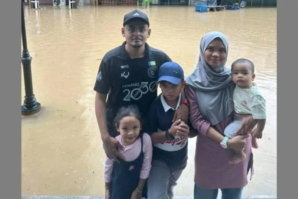 Ahmad Kamil dan keluarganya di hadapan hotel mereka di Hatyai yang ditenggelami banjir.