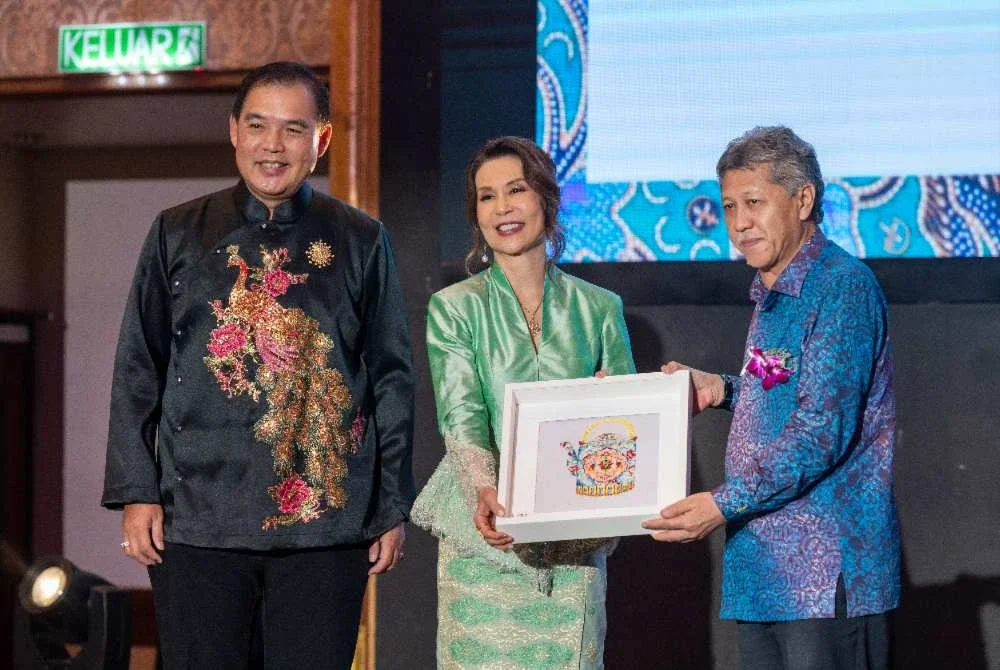 Vivienne (tengah) menyampaikan cenderamata kepada Shaharuddin.