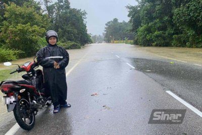 Nik Hasmayati (kiri) dari Melor terpaksa berpatah balik ketika dalam perjalanan ke tempat kerja di Kota Bharu selepas laluan di Kampung Seribong dinaiki air sedalam kira-kira 0.4 meter. Foto: HAZELEN LIANA KAMARUDIN