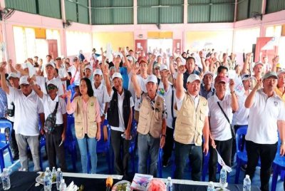 Joachim (tengah) melaungkan slogan ‘Tatap GRS’ bersama penyokong yang hadir dalam program Mirumo-rumo di Dewan mini, Kg Timbua, Kundasang