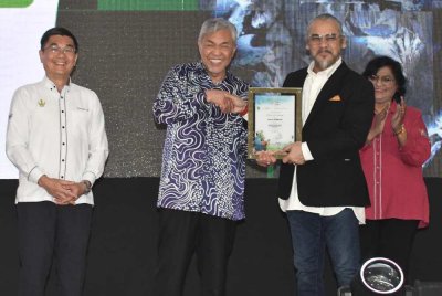 Awie (kanan) menerima watikah pelantikan sebagai Duta Alam Sekitar Perak daripada Ahmad Zahid sempena Sambutan Hari Alam Sekitar Peringkat Negeri Perak 2025 di Kompleks UMNO Bagan Datuk pada Ahad.