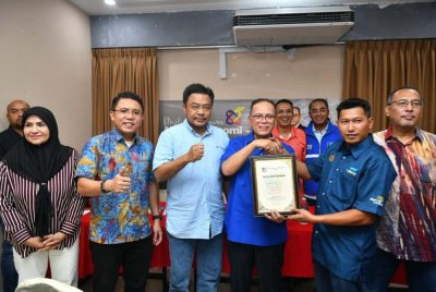 Wan Rosdy (tiga dari kiri) menyampaikan Sijil Penubuhan MyGiG Chapter Sabah kepada wakil pemandu e-hailing pada Ahad.