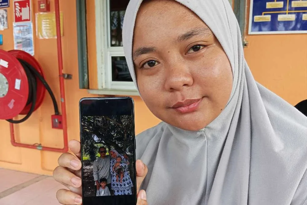 Norfaqeah menunjukkan gambar kenangan keluarga ketika ditemui di Hospital Pontian pada Isnin.