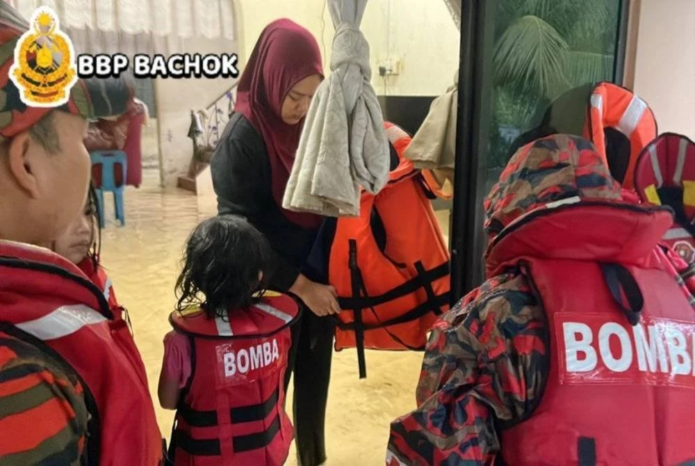 Anggota penyelamat membantu memindahkan mangsa banjir yang terlibat. Foto ihsan BBP Bachok