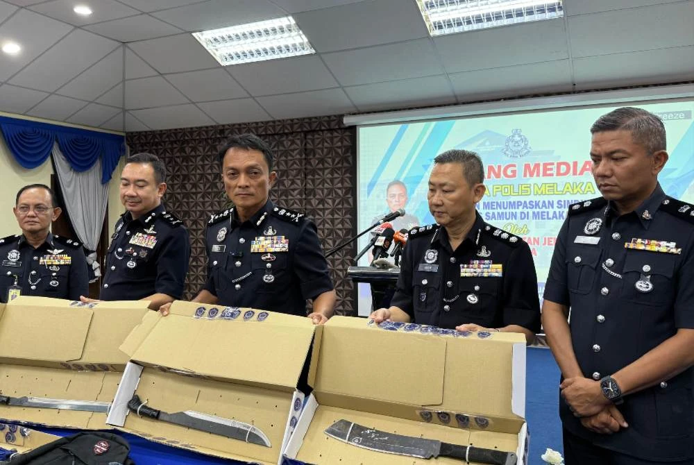 Dzulkairi (tengah) menunjukkan parang digunakan suspek.