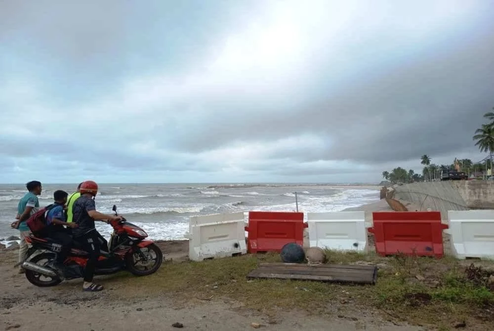 Penduduk setempat meninjau keadaan projek pembinaan jalan Pantai Batu Rakit yang berdepan risiko runtuhan akibat MTL yang melanda tahun ini.