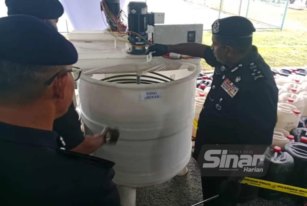 Hussein (kanan) menunjukkan mesin dipercayai digunakan untuk memproses dadah.