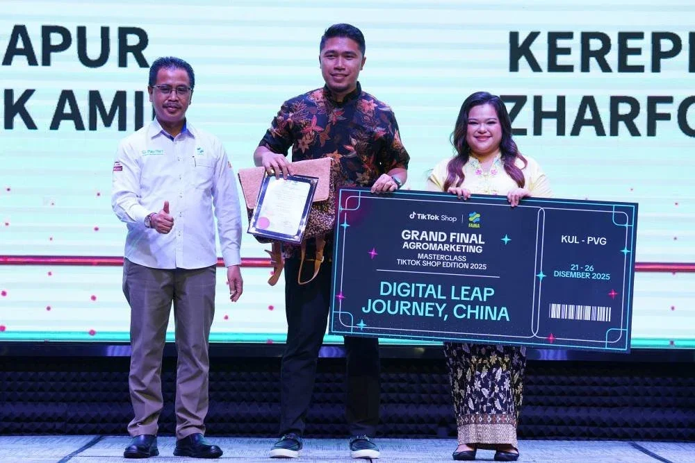 Pegawai Eksekutif Pemasaran, Mohd Syahme Azhar (tengah) menerima hadiah daripada Abdul Rashid dan Nur Azre.