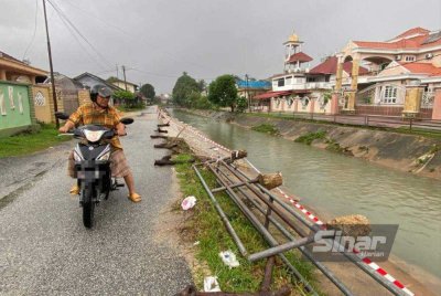 Fauzi menunjukkan lokasi runtuhan yang dibimbangi boleh mendatangkan bahaya kepada pengguna jalan raya serta penduduk. Foto: HAZELEN LIANA KAMARUDIN