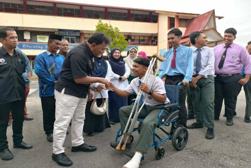 Rahmad (kiri) menyantuni calon SPM di SMK Air Molek pada Selasa.