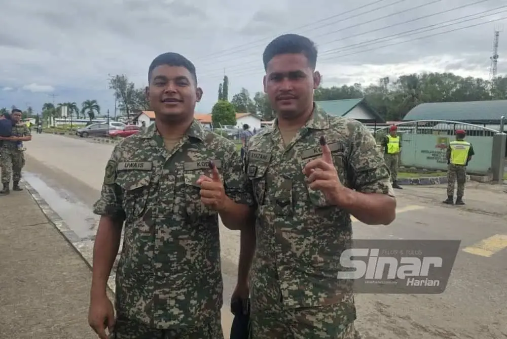 Prebet Uwais (kiri) bersama rakannya, Prebet Muhammad Syazani selesai menunaikan tanggungjawab sebagai pengundi di Sekolah Agama Rakyat Kem Lok Kawi, Putatan.