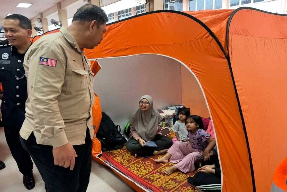 Meor Ismail (kiri) melawat mangsa banjir yang berada di PPS di SMK Geting. - Foto Sinar Harian/Adila Sharinni Wahid