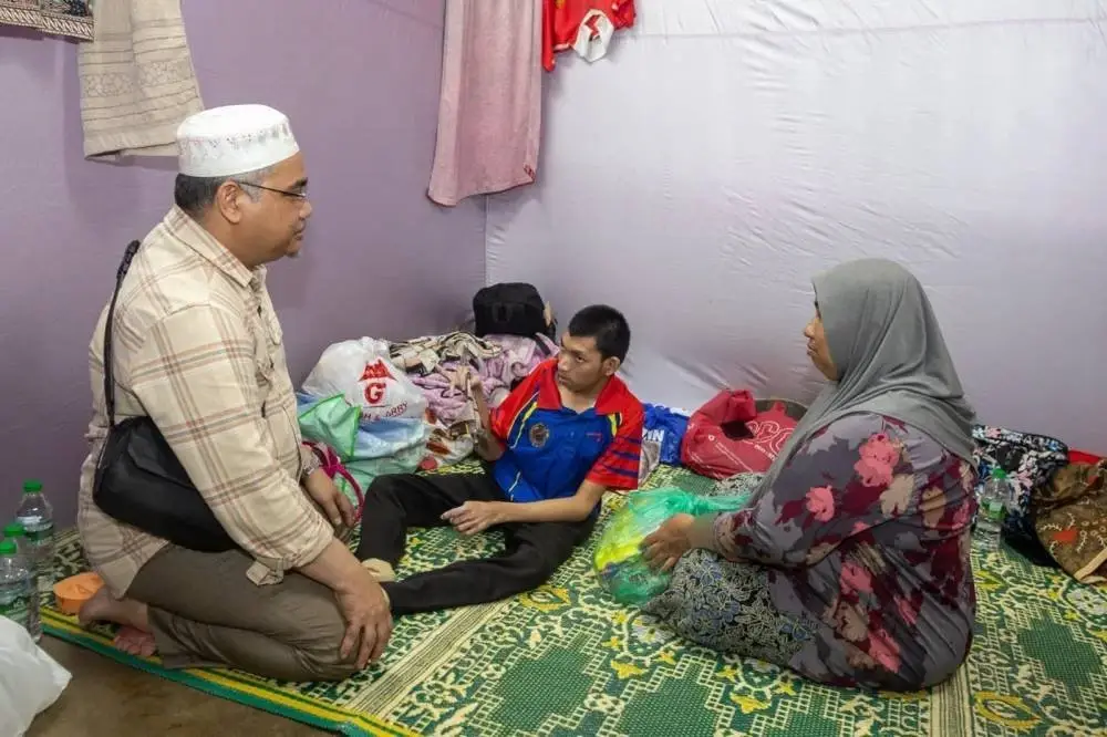 Mohd Asri (kiri) bertanyakan khabar kepada penghuni PPS di kawasan DUN Demit yang terjejas banjir pada Selasa. Foto UPKN