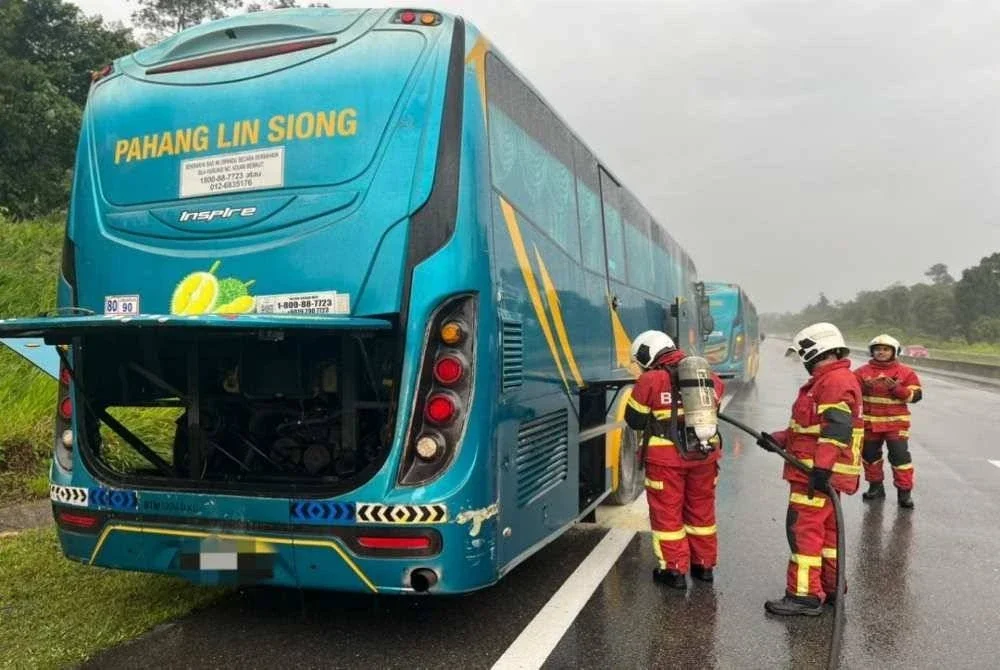 Anggota bomba melakukan semburan penyejukkan ke bahagian enjin bas yang terbakar bagi mengelak kebakaran berulang. Foto: JBPM Pahang