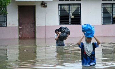 Penduduk, Taizatul Rohimah Ibrahim, 49, bersama anaknya, menyelamatkan barangan susulan rumah mereka dinaiki air akibat hujan berterusan sejak semalam, ketika tinjauan fotoBernama di Gelong Gajah, Kampung Kedah pada Sabtu. 