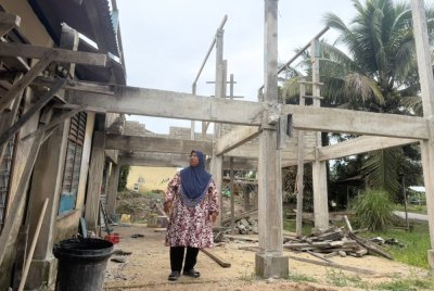 Kamsawiah menunjukkan stor baharu yang lebih tinggi dan luas dibina bagi menyimpan barangan di rumahnya setiap kali tiba musim banjir.