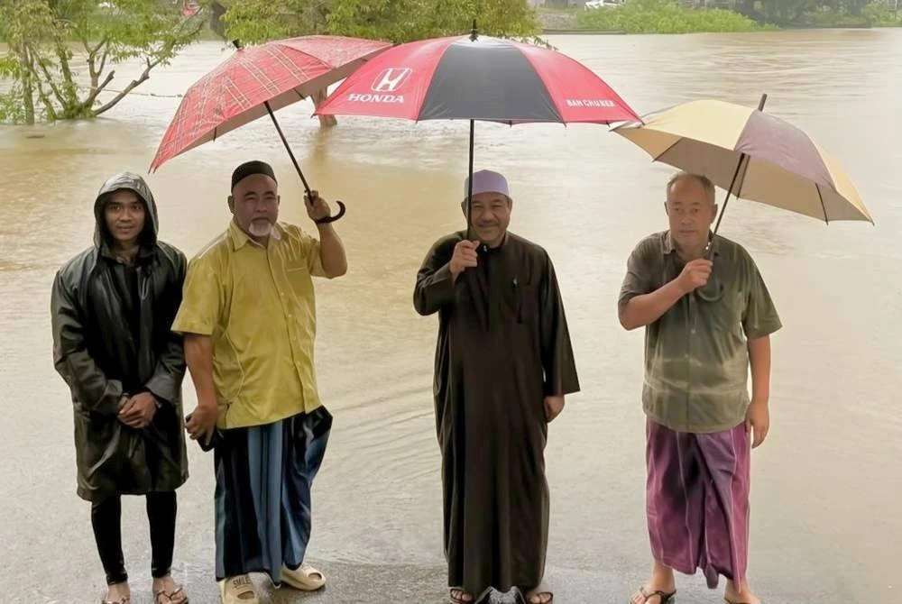 Mohd Nassuruddin (dua dari kanan) bersama penghulu meninjau keadaan terkini di kawasan Kampung Jeram Perdah apabila air Sungai Golok mulai melimpah pada Rabu. Foto: FB Mohd Nassuruddin