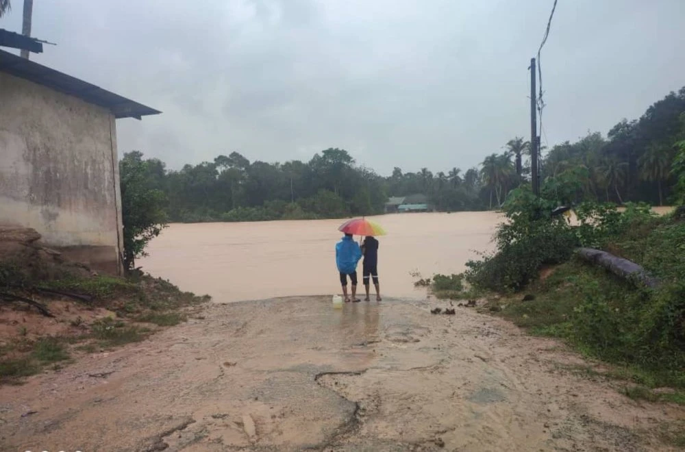 Penduduk melihat Jambatan Tanjung Kala yang dilimpahi sungai hingga tidak dapat dilalui. 
