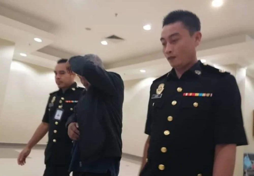 Tertuduh diiringi pegawai SPRM keluar dari mahkamah selepas sebutan kes selesai dibacakan pada Rabu.