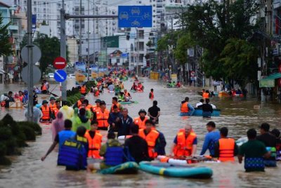 Orang ramai termasuk sukarelawan meredah banjir selepas hujan lebat berterusan melanda kebanyakan kawasan di Vietnam.