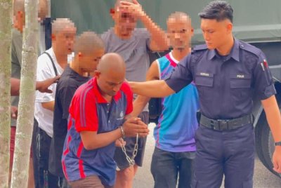 Tertuduh (berbaju merah) menghadapi dua pertuduhan membunuh dua beranak pada 18 Oktober lalu.