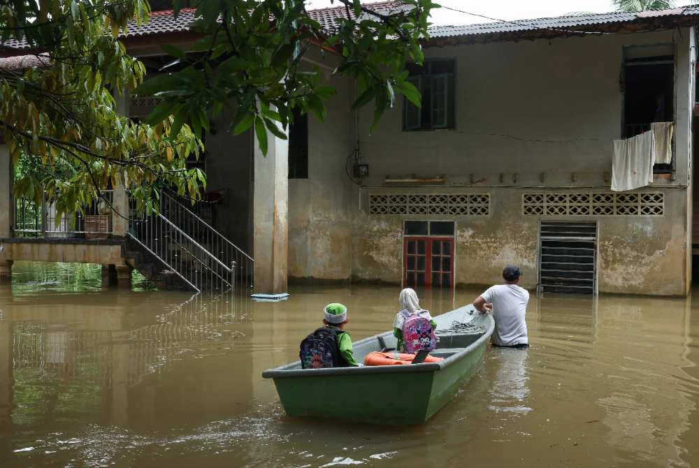Penduduk Kampung Tersang, Pasir Mas menggunakan bot fiber untuk melakukan aktiviti harian selepas kawasan kediaman mereka dinaiki air apabila Sungai Golok mula melimpah ke beberapa perkampungan berhampiran. - Foto: Bernama