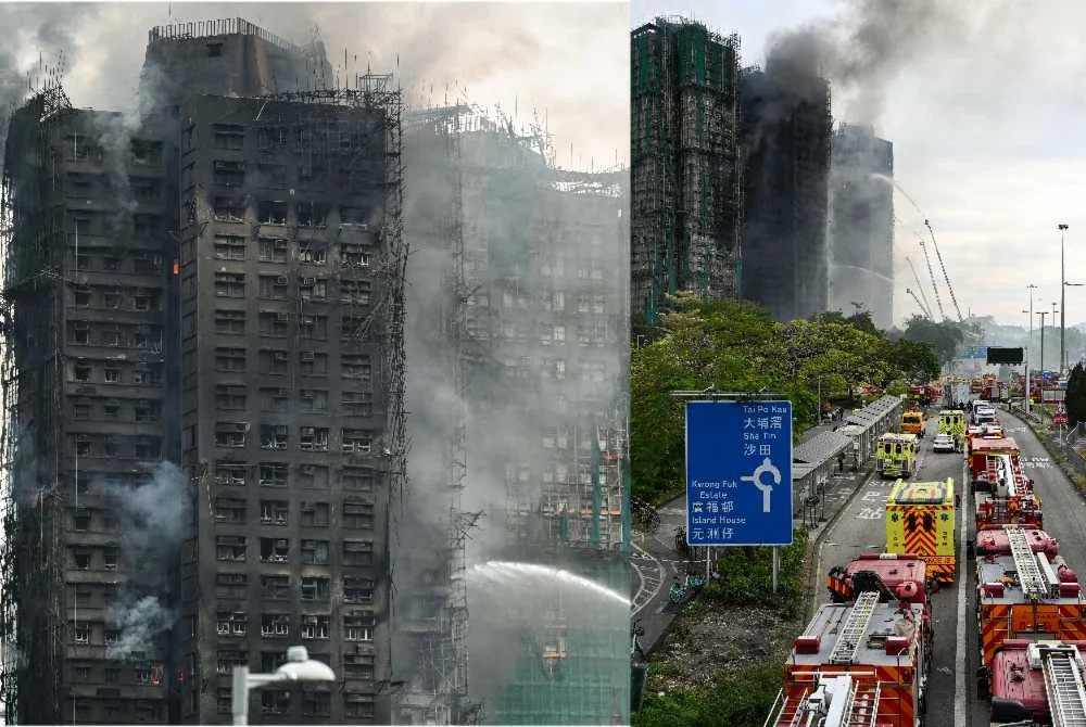 Anggota bomba menyembur air ke arah api ketika kebakaran besar terus memusnahkan beberapa blok pangsapuri di perumahan Wang Fuk Court, daerah Tai Po.