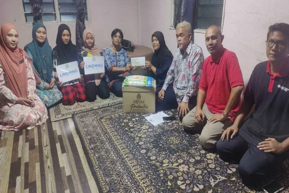 Thavamani (lima dari kiri) menyampaikan sumbangan kepada Rafidah (empat dari kanan) semasa sesi ziarah prihatin dan penyerahan baucar FPM di sini pada Khamis.