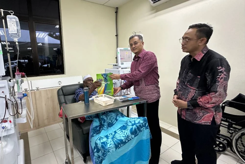 Mohamad menyampaikan cenderahati kepada seorang pesakit.