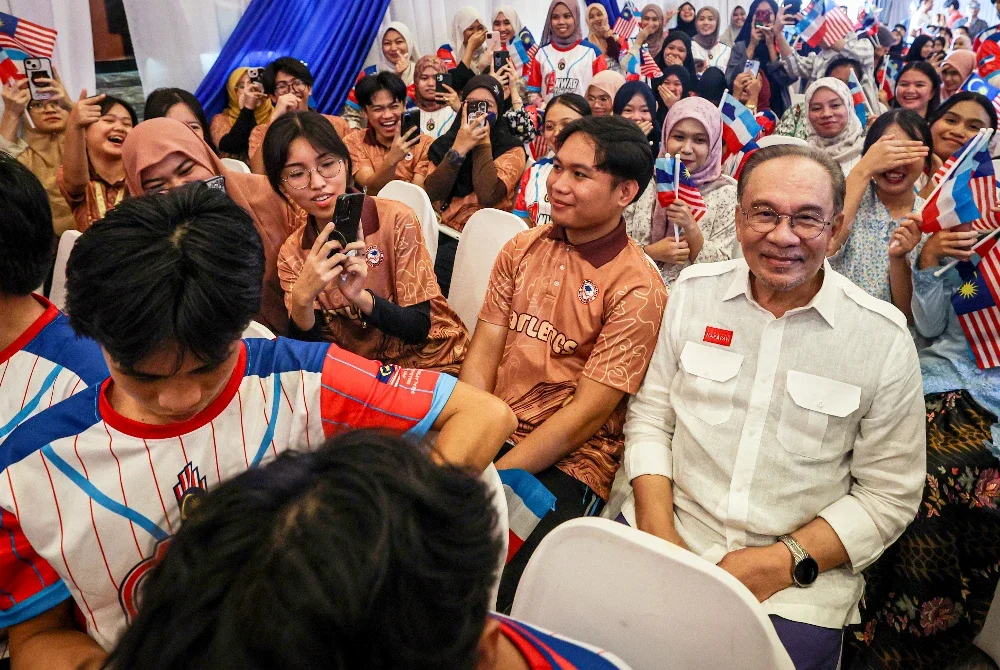 Anwar (kanan) beramah mesra dengan anak-anak muda pada program Bersama PMX Sayang Sabah Dengan Pemuda Inanam di Kota Kinabalu hari ini. Foto Bernama 