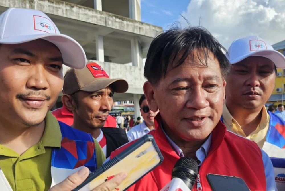 Awang Husaini (tengah) ketika ditemui pemberita di Putatan.