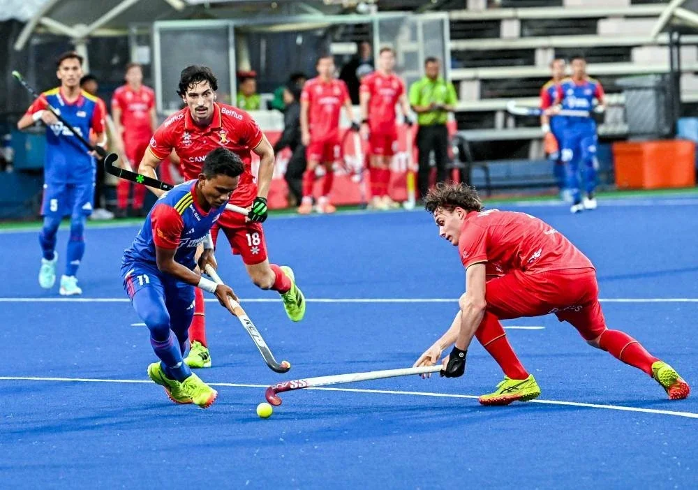 Pemain negara, Anuar Akhimullah (kiri) bersaing dengan pemain Belgium pada saingan Piala Sultan Azlan Shah di Stadium Hoki Azlan Shah pada Khamis. Foto: Bernama
