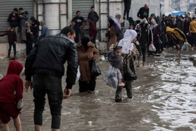 Penduduk Palestin terpaksa meredah banjir di Bandar Gaza. Foto AFP