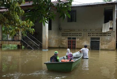Penduduk Kampung Tersang, Pasir Mas menggunakan bot fiber untuk melakukan aktiviti harian selepas kawasan kediaman mereka dinaiki air apabila Sungai Golok mula melimpah ke beberapa perkampungan berhampiran. - Foto: Bernama
