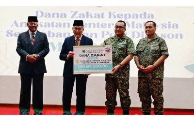 Abdul Aziz (dua dari kiri) menyerahkan Geran Kerohanian Wakalah MAINS kepada Mohd Rashidi (dua dari kanan) pada program 'Perwira Berzakat, Negeri Berkat' bersama MAINS di Akademi Tentera Darat di sini pada Selasa.