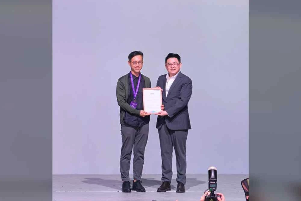 Justin (kanan) mewakili HONOR menyampaikan AYES Outstanding Contribution Award pertama kepada pereka terkenal Malaysia, Joseph Foo (kiri).