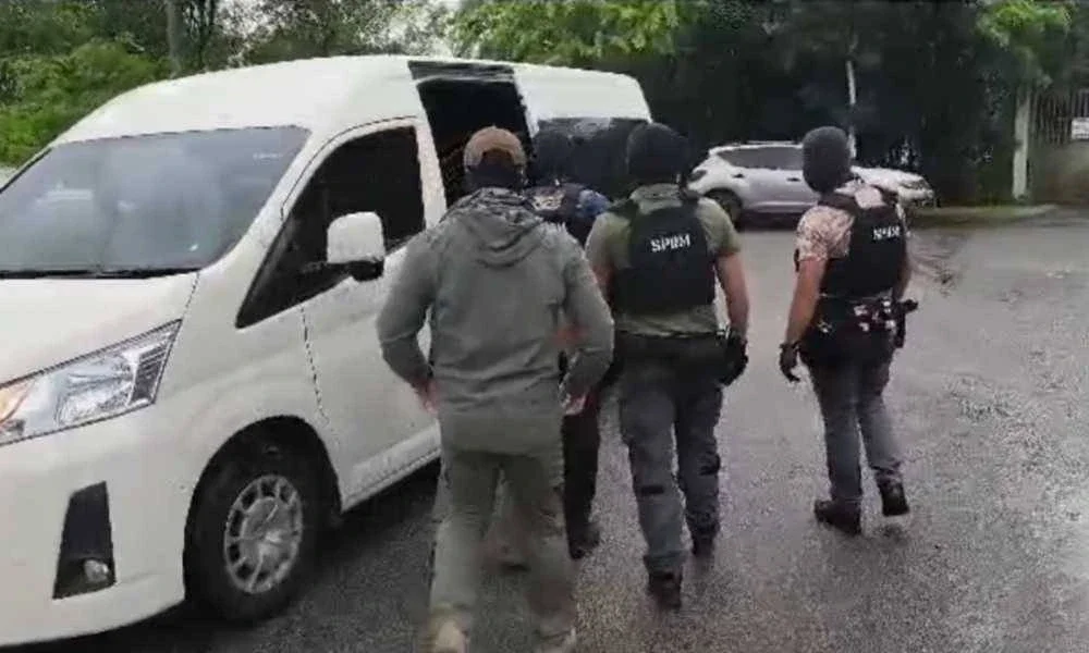 Albert dikelilingi pegawai bersenjata yang memakai balaklava.