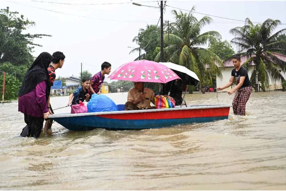 Sebahagian penduduk menggunakan bot untuk berpindah ke kawasan selamat selepas kediaman mereka dinaiki air ekoran hujan lebat berterusan, ketika tinjauan di Kampung Sena Rendang, Marang pada Jumaat. Foto Bernama
