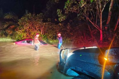Keadaan kereta dinaiki mangsa yang hampir tenggelam selepas terjatuh ke dalam longkang ketika cuba redah air banjir di atas jalan. FOTO APM RAUB