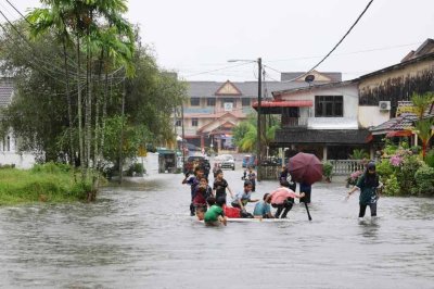 Kelihatan sekumpulan kanak-kanak bermain air banjir di hadapan rumah mereka semasa tinjauan di Surau Padang Luar, Kuala Ibai, pada Jumaat. Foto Bernama 