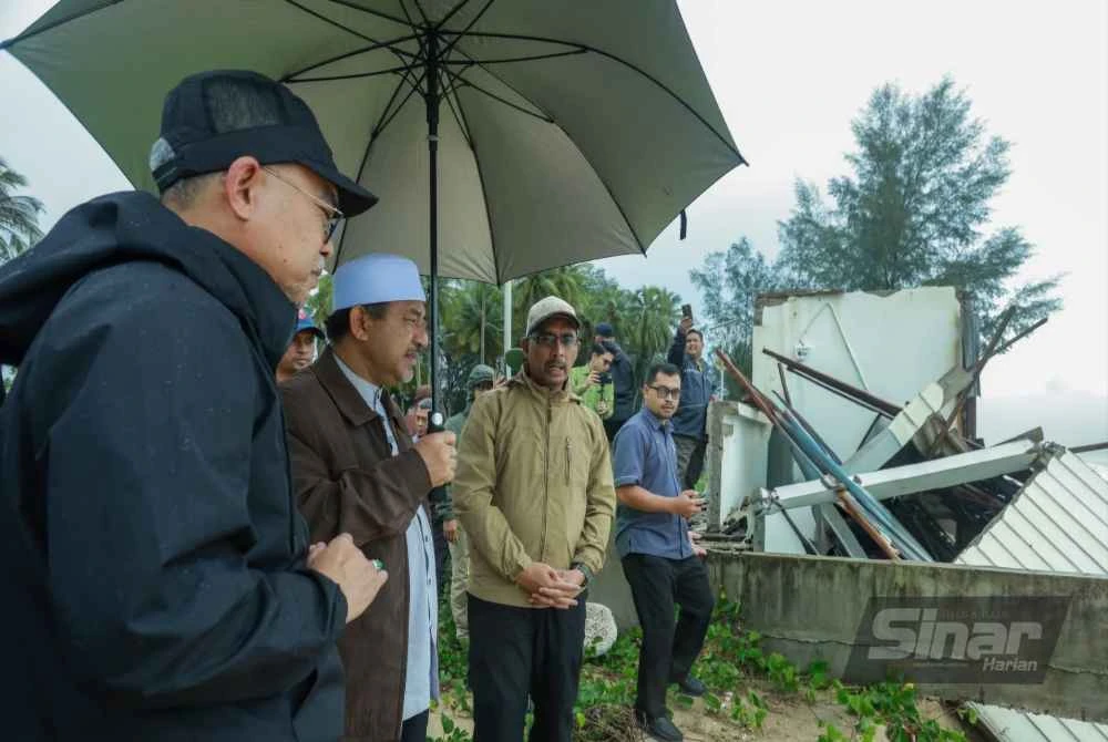 Mohd Nassuruddin (dua dari kiri) semasa melakukan tinjauan di kawasan terjejas akibat hakisan di Pantai Bisikan Bayu, Pasir Puteh pada Rabu lalu.